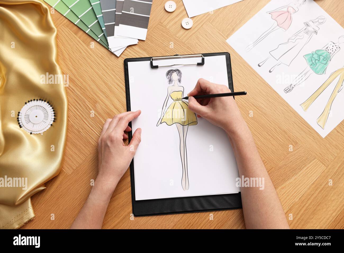 Fashion designer drawing sketch of beautiful dress at wooden table, top  view Stock Photo - Alamy