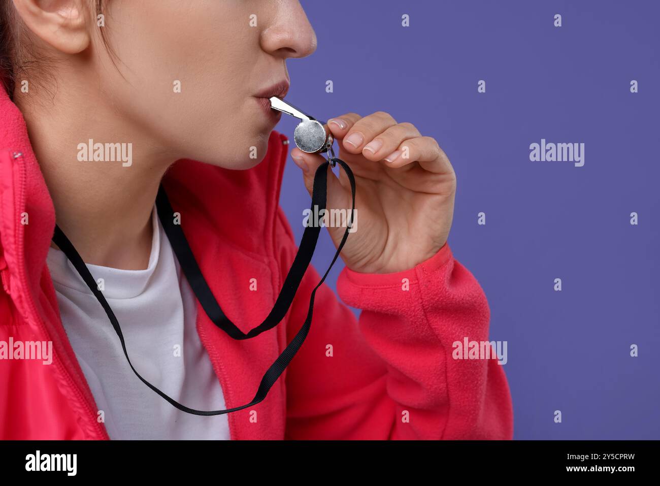 Woman blowing whistle on purple background, closeup Stock Photo Alamy