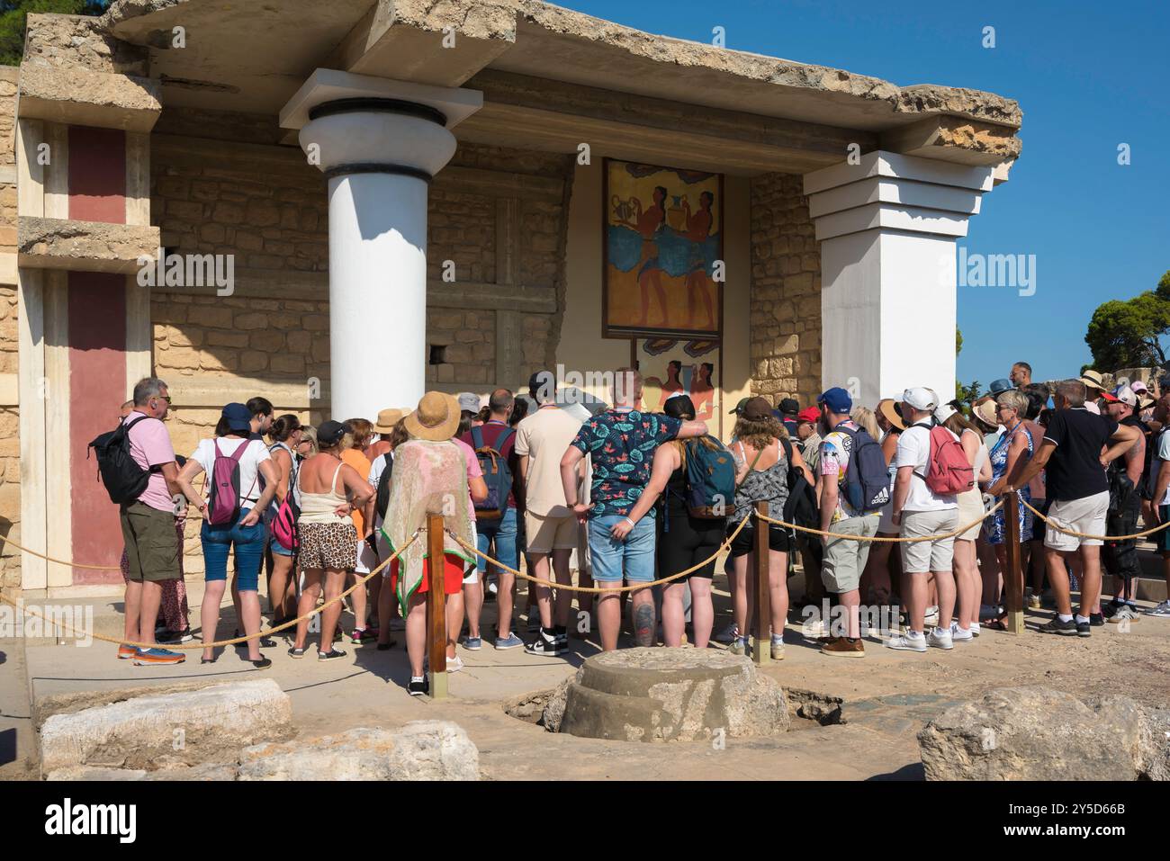 Corridor Of The Procession Knossos Palace, rear view of a tour group studying colorful frescoes sited in the Corridor Of The Procession, Knossos Crete Stock Photo