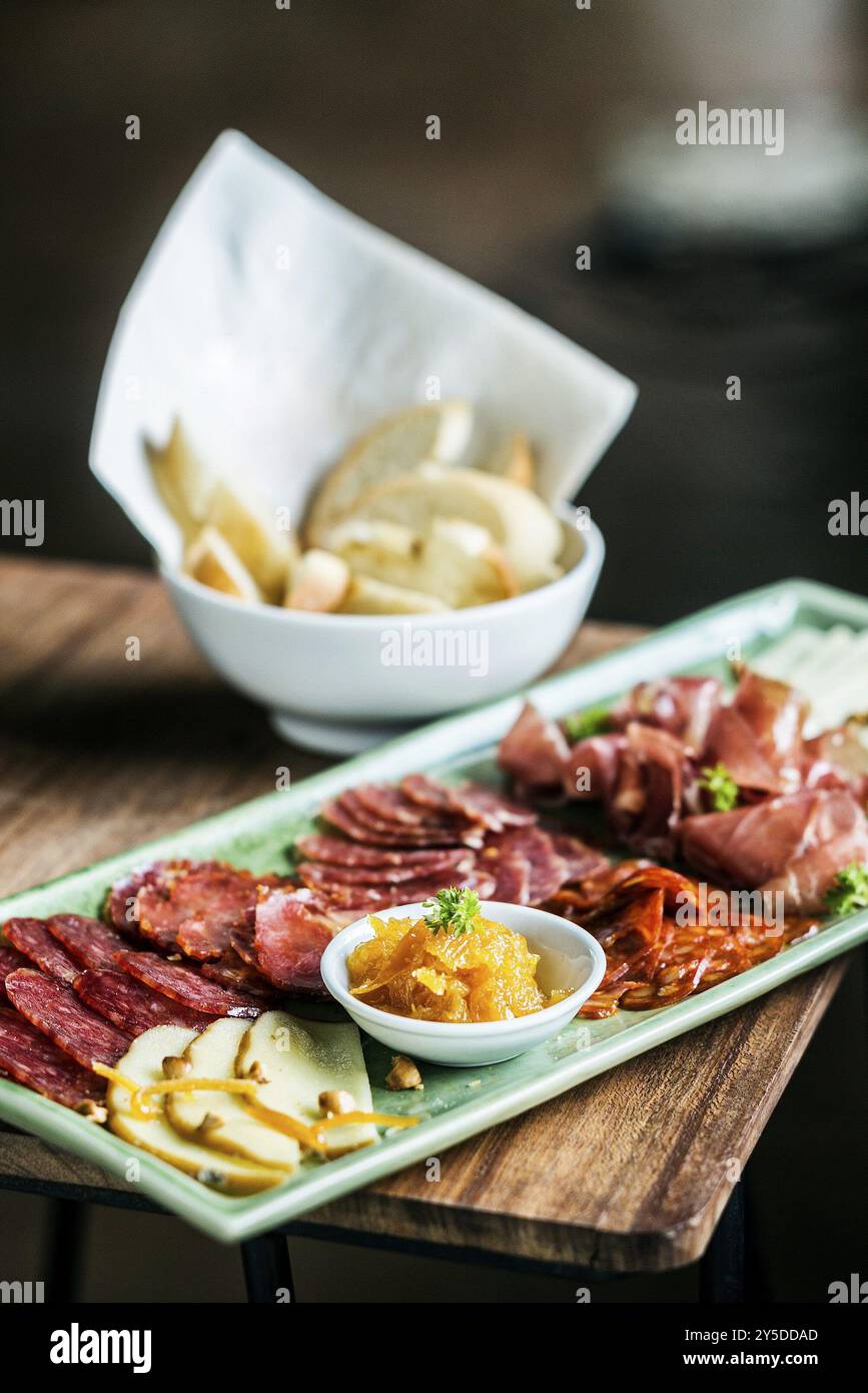 Spanish traditional smoked meats serrano ham chorizo and cheese platter starter dish with quince jam and bread Stock Photo