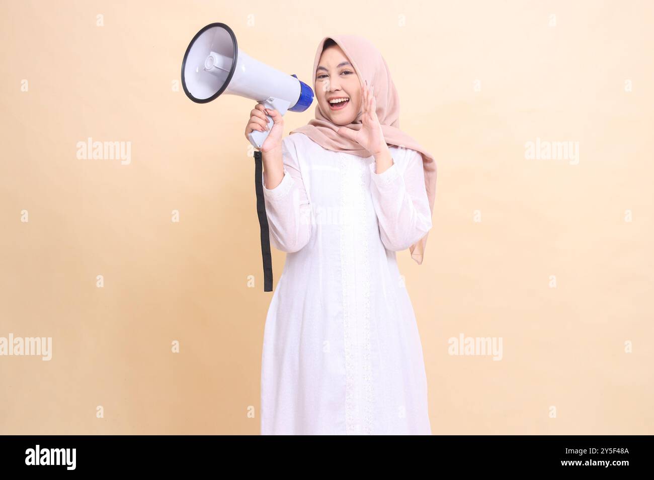 girl asian muslim wearing a hijab at the camera shouts cheerfully ...