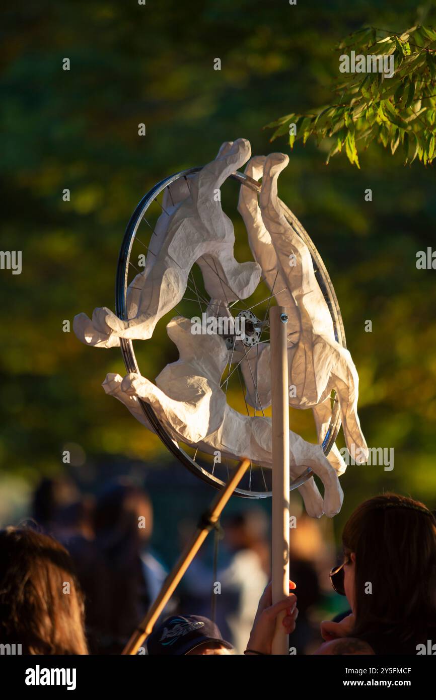 Seattle, Washington, USA. 21st September, 2024. A womanholds a fanciful lantern in the form of three hares, a historical motif, at the Luminata autumnal equinox celebration at Seattle’s Green Lake Park. The Fremont Arts Council welcomes all to the procession around Green Lake to celebrate the autumnal equinox with illuminated costumes, lanterns and art. Credit: Paul Christian Gordon/Alamy Live News Stock Photo