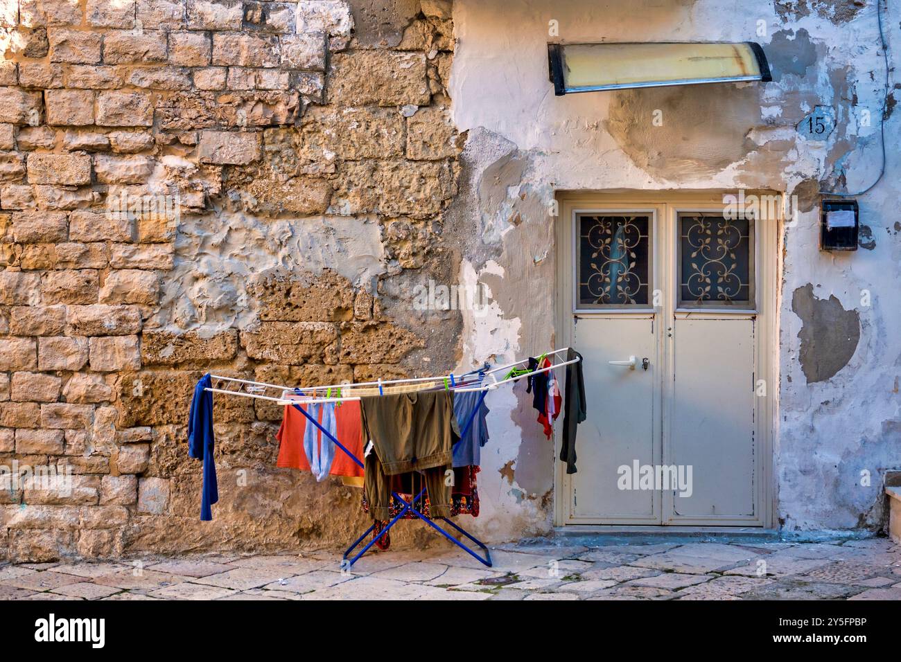 Clothes drying on racks are set against a wall in Bari Vecchia, Bari Italy. Stock Photo