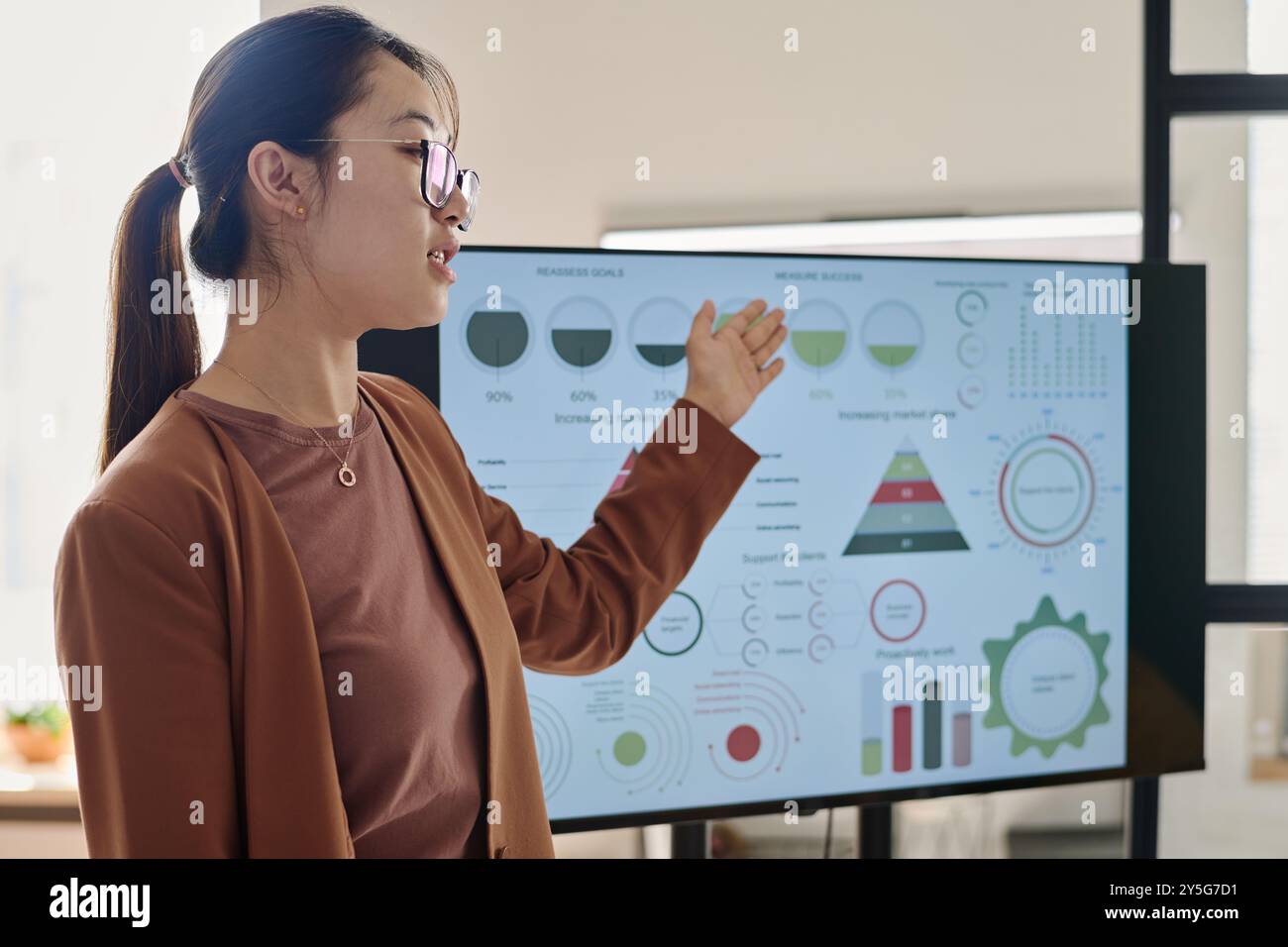Asian woman demonstrating data insights with interactive charts on ...