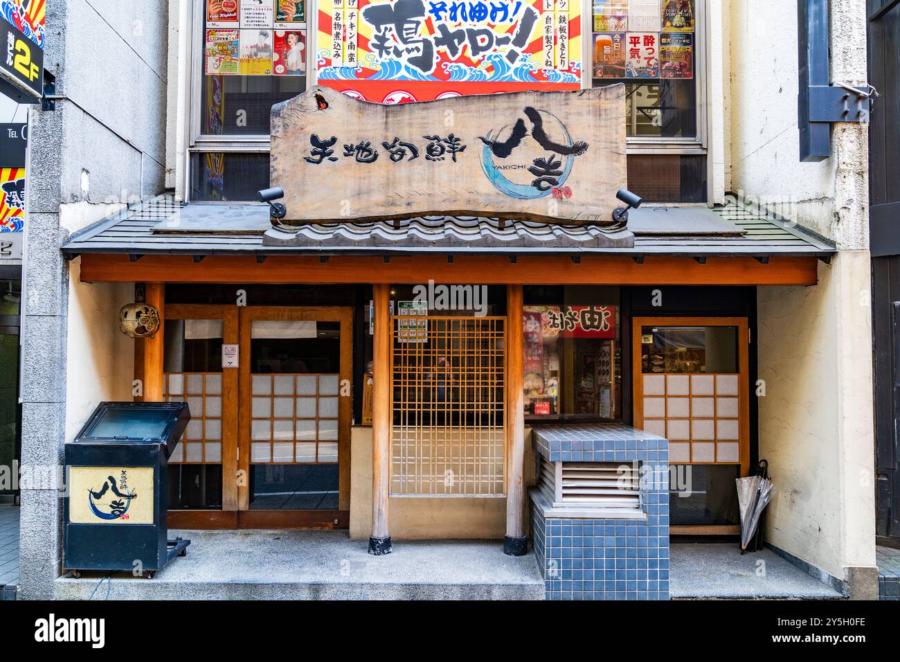 Wooden and concrete frontage of a small Japanese seafood Izakaya, (bar come restaurant), called