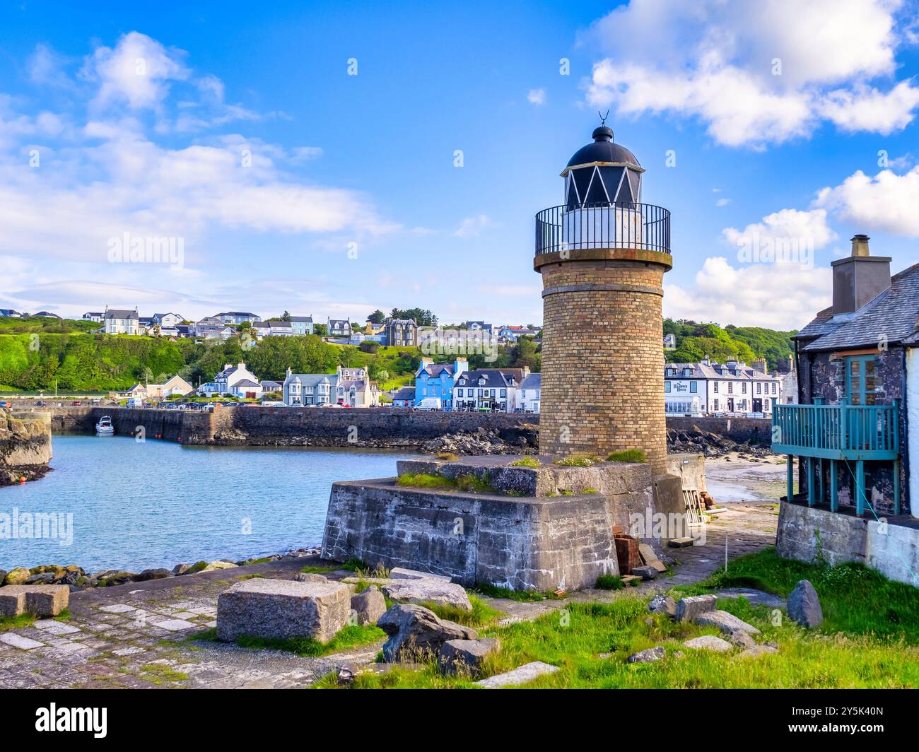 10 June 2024: Portpatrick, Dumfries and Galloway, Scotland - The lighthouse, village and harbour on a sunny spring morning. Stock Photo