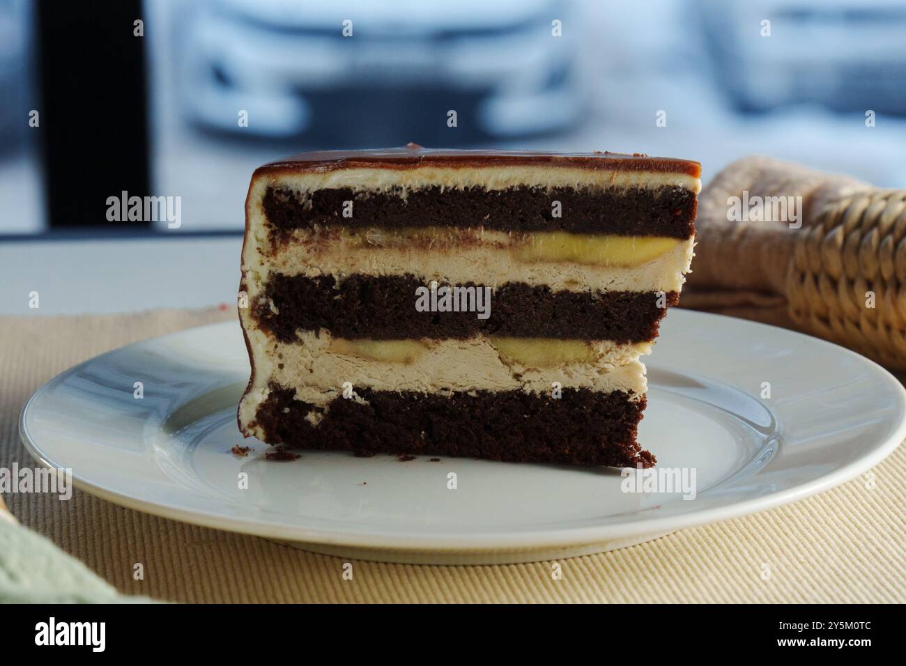 Layers of rich chocolate cake interspersed with velvety cream frosting create a tantalizing dessert experience, perfect for any celebration or indulge Stock Photo