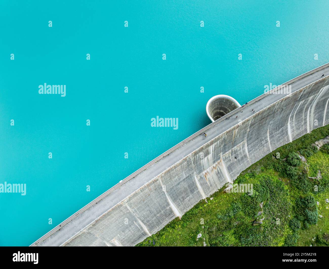 Dam of the Moiry lake,  Lac de Moiry, turquoise glacial water,  parking lot and restaurant at the dam, aerial view, Valais, Switzerland Stock Photo