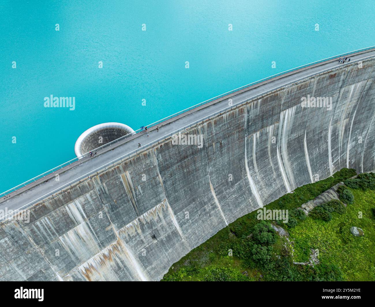 Dam of the Moiry lake,  Lac de Moiry, turquoise glacial water,  parking lot and restaurant at the dam, aerial view, Valais, Switzerland Stock Photo