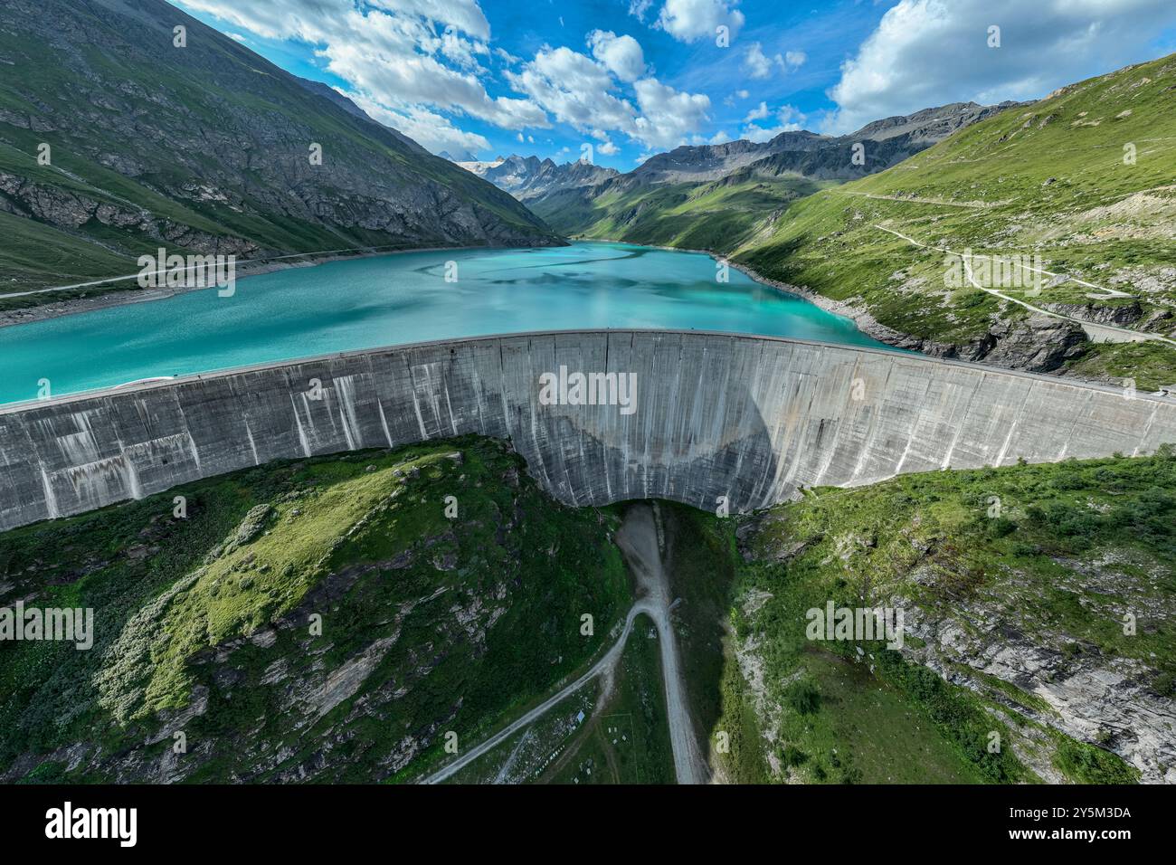 Dam of the Moiry lake,  Lac de Moiry, turquoise glacial water,  parking lot and restaurant at the dam, aerial view, Valais, Switzerland Stock Photo