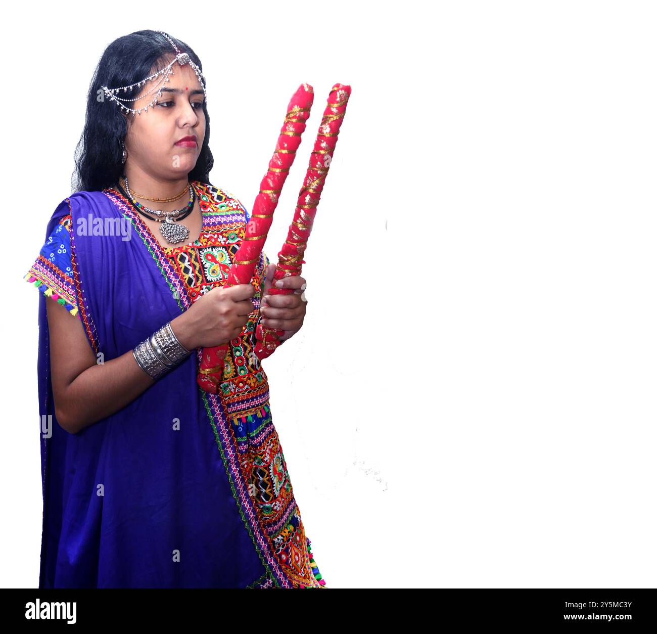 Gujarati traditional woman with dandiya sticks on a white background, during Navratri Celebrations,Indian women in traditional culture. selective focu Stock Photo