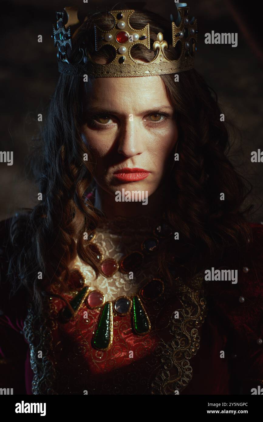 medieval queen in red dress with crown on dark gray background Stock ...