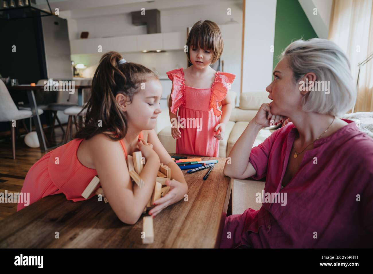 Mother spending quality time with daughters at home playing games Stock Photo