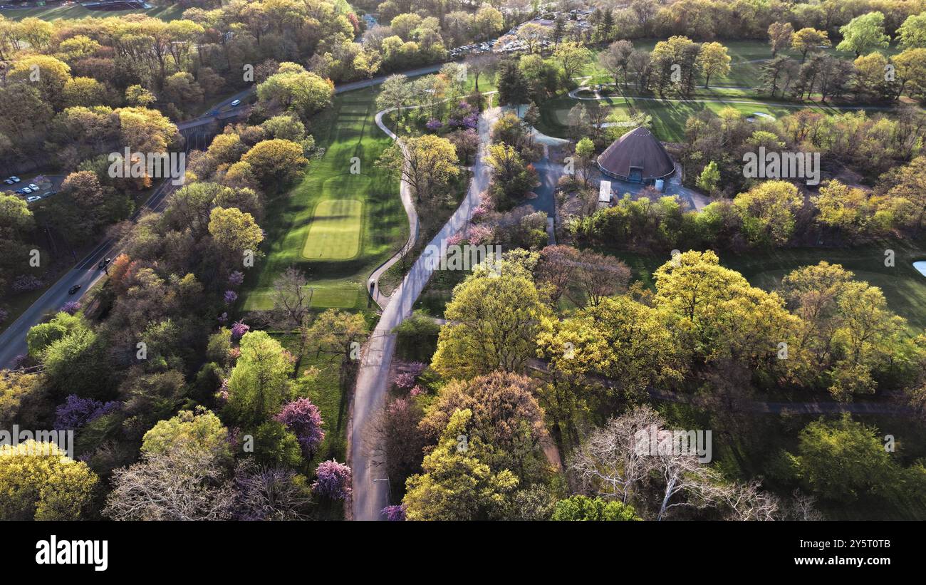 Aerial view of a lush green park with winding paths and a domed ...