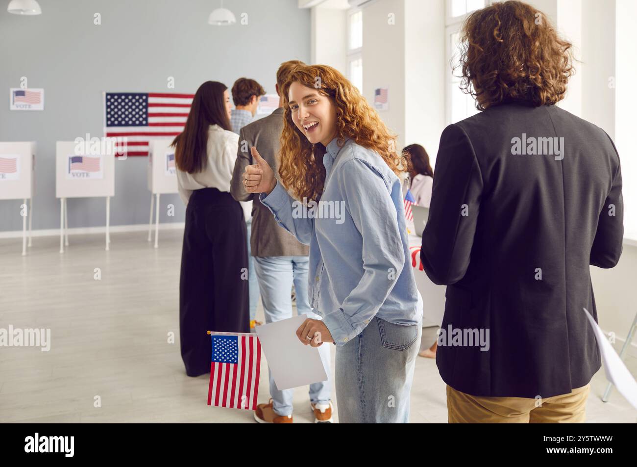 Happy young American woman shows thumbs up while standing in line at ...