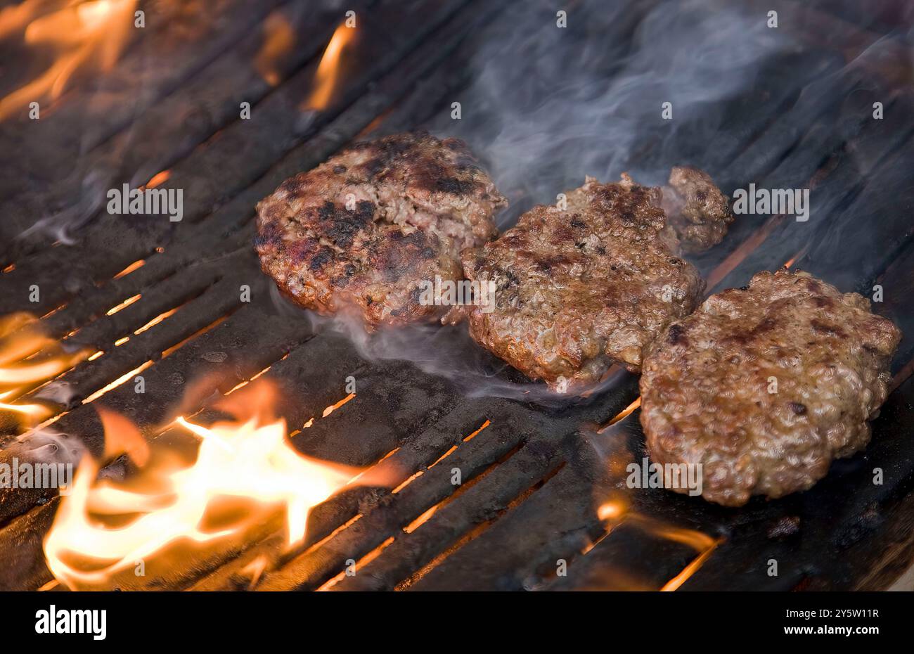 Home made beef burgers cooking on a fiery barbecue Stock Photo - Alamy
