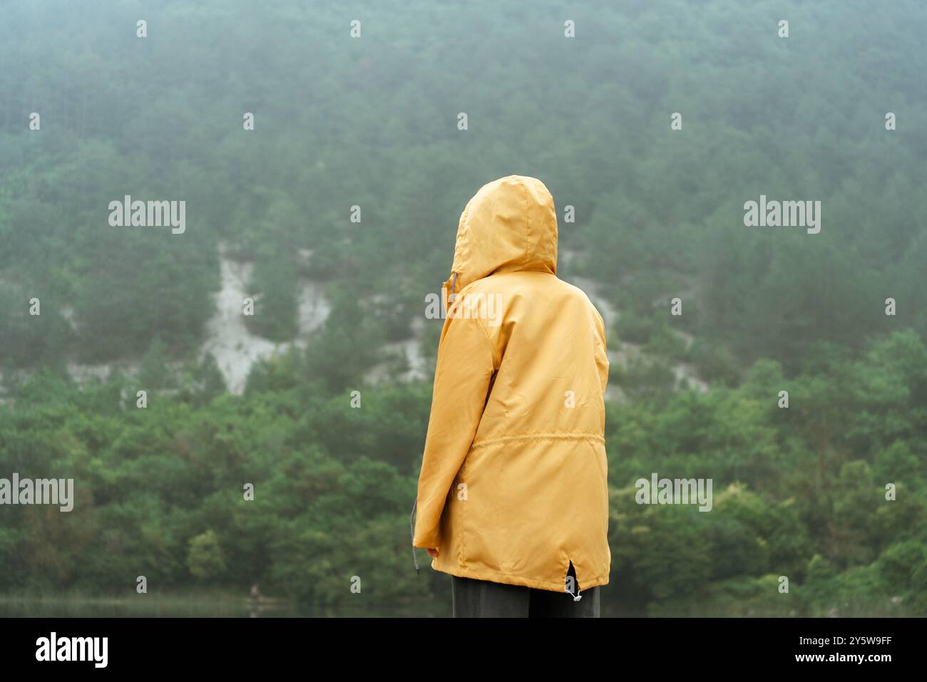 Young woman wearing yellow raincoat hi-res stock photography and images ...