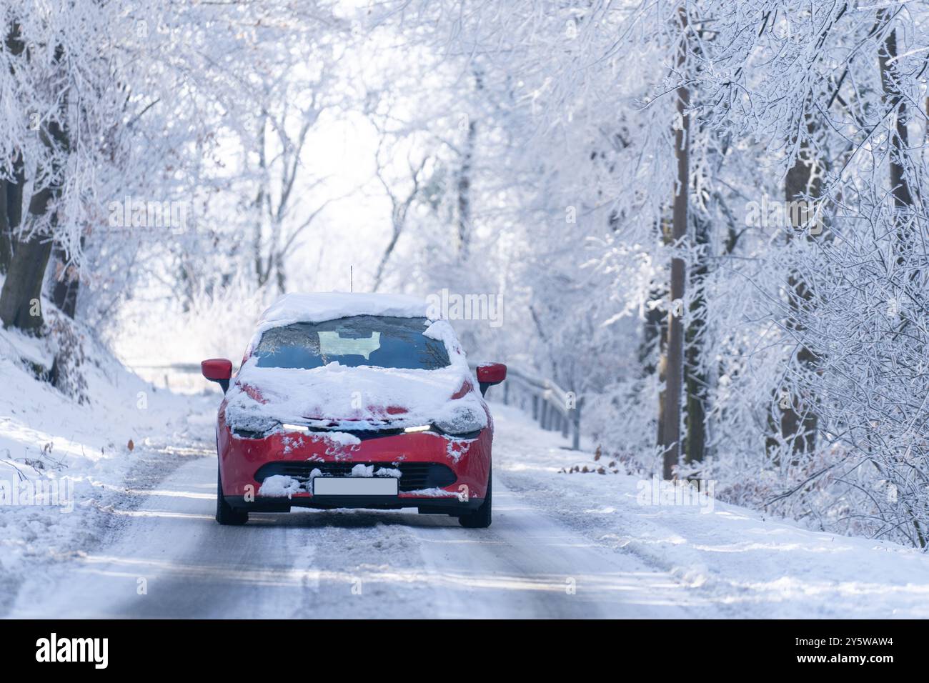 Car on a winter road through a snow covered forest. Stock Photo