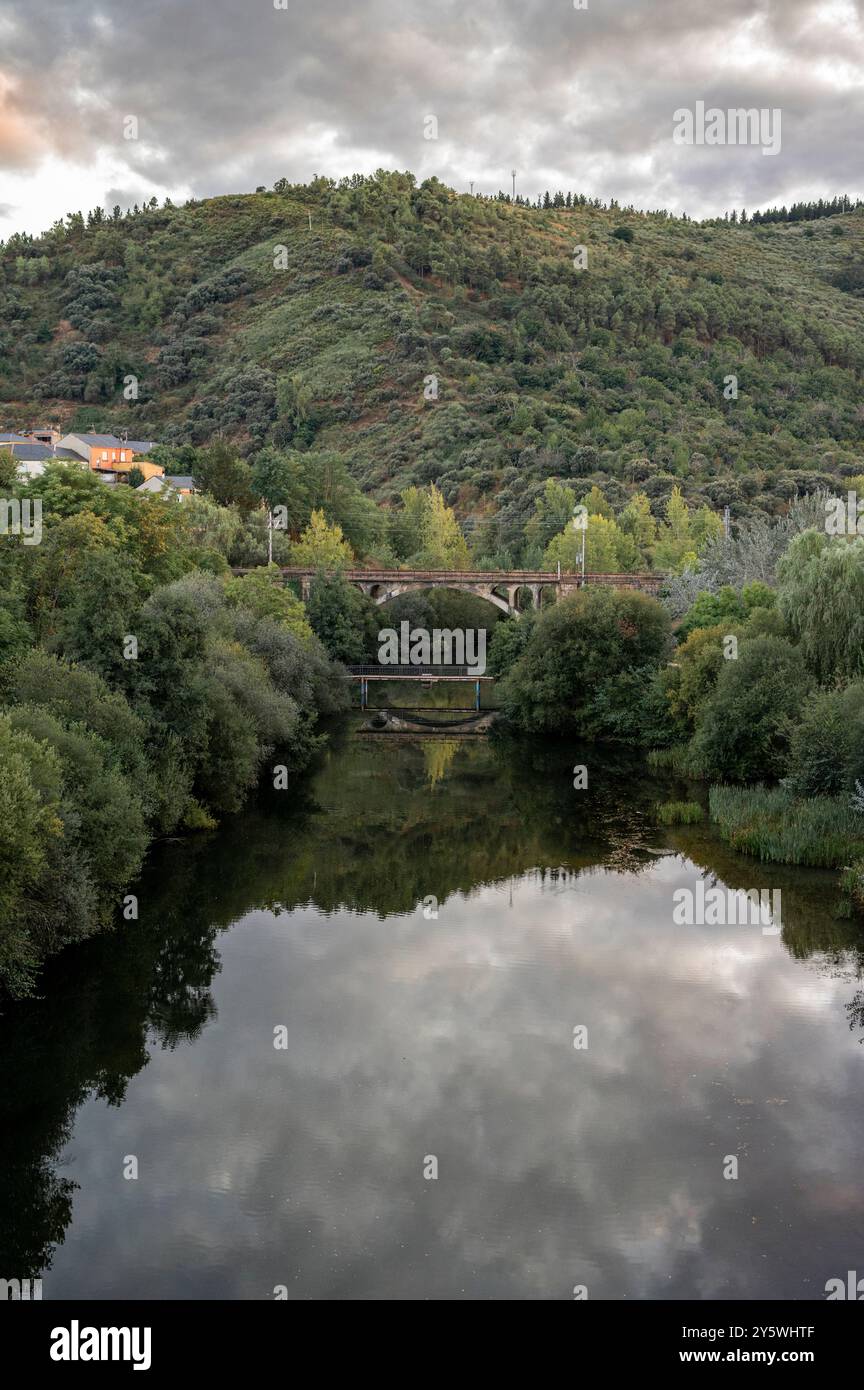 Serene River Landscape with Historic Stone Bridge and Lush Foliage ...