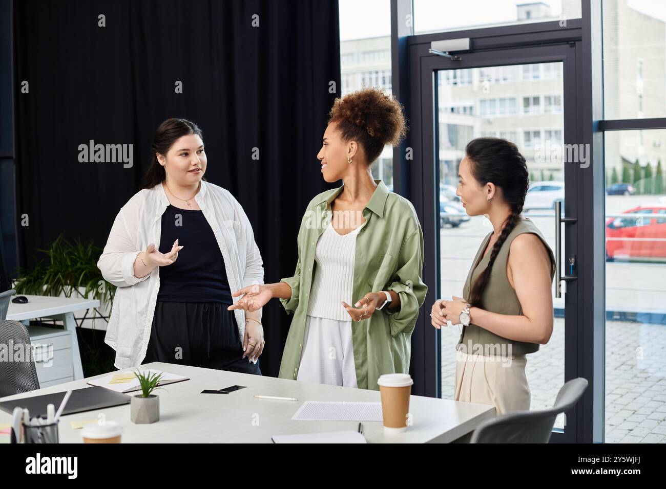 Three businesswomen engage in discussion hi-res stock photography and ...