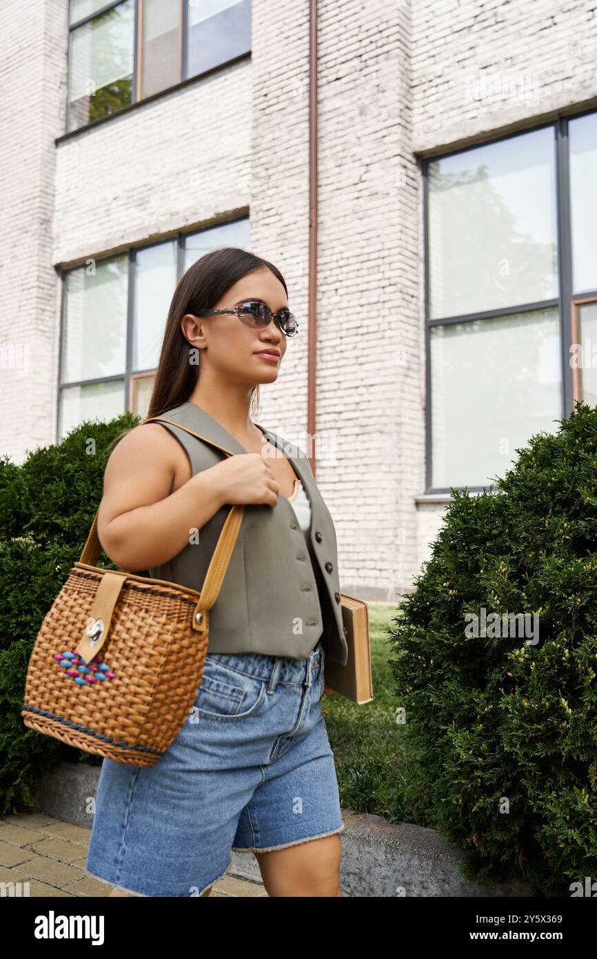 A stylish brunette woman with a short stature strolls through a vibrant urban setting, enjoying a lovely day outdoors. Stock Photo