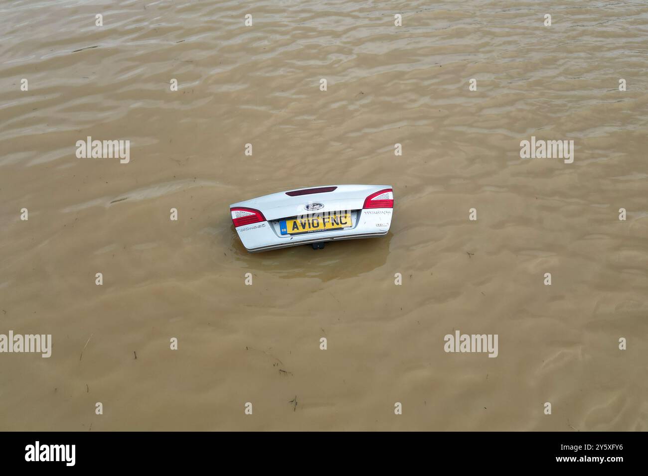 The open boot of a car is visible above the water where the vehicle is submerged in flood water on a421 in Marston Moretaine, Bedfordshire. Parts of Britain have been struck by flash floods after some areas saw more than a month's worth of rain in 24 hours. Heavy rainfall has seen parts of Northamptonshire, Bedfordshire and London submerged causing widespread travel disruption and damage to properties. Picture date: Monday September 23, 2024. Stock Photo