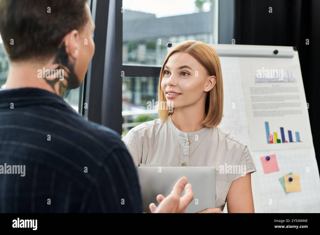 Two young professionals share ideas and collaborate in a modern office ...