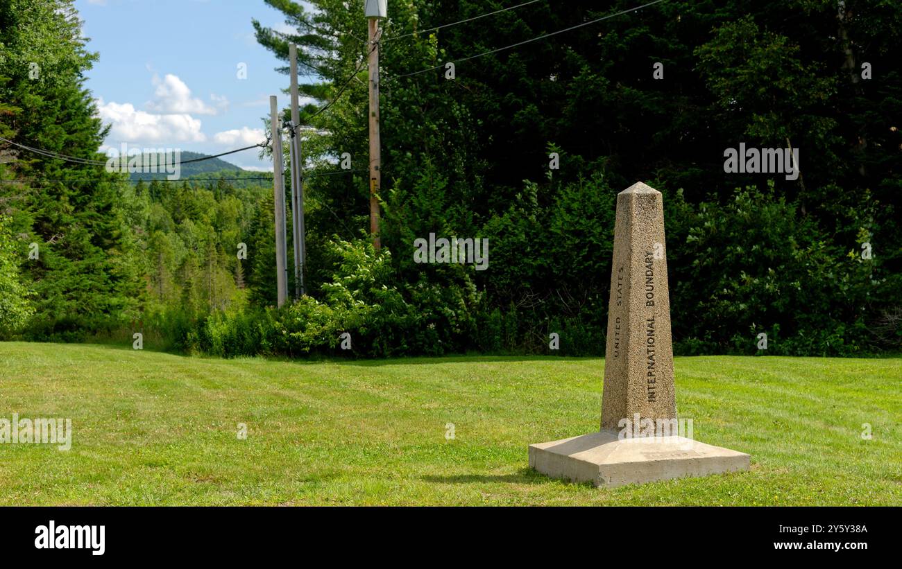 Franklin County, Maine, USA - July 19, 2024: A stone boundary marker stands on the international border between Canada and the United States. Stock Photo