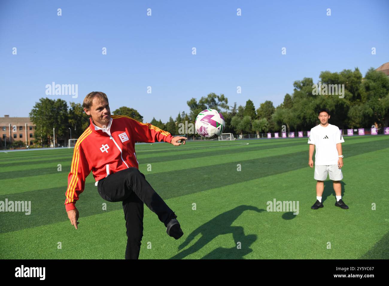 Beijing, China. 23rd Sep, 2024. Adidas Global CEO Bjorn Gulden (L) kicks the ball during his visit to Tsinghua University in Beijing, capital of China, Sept. 23, 2024. Credit: Dai Tianfang/Xinhua/Alamy Live News Stock Photo