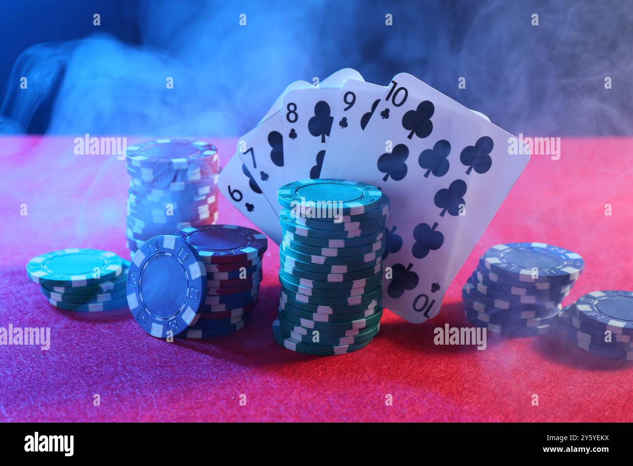 Poker chips and playing cards on pink table Stock Photo