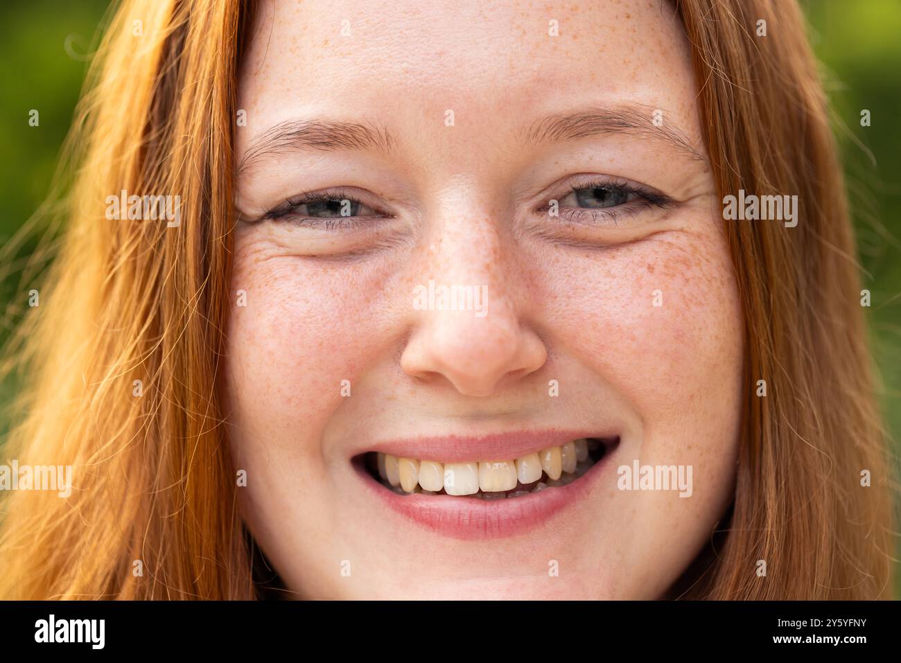 Smiling woman with freckles enjoying outdoor hangout Stock Photo - Alamy