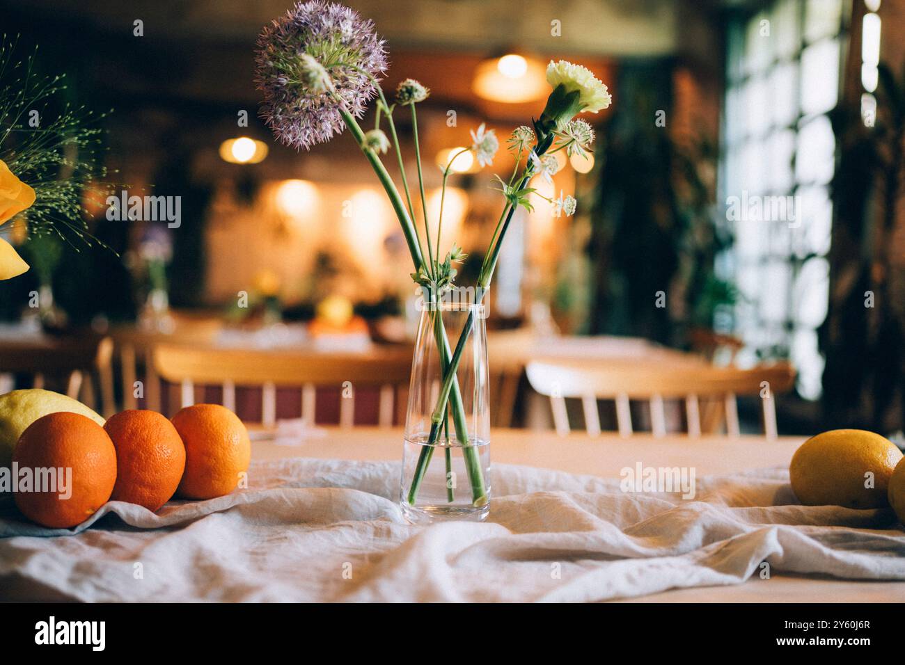 Minimalist Floral Arrangement with fruits and linen on a Wooden Table Stock Photo