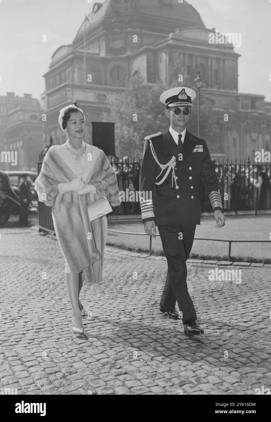 King Bhumibol Adulyadej of Thailand, Queen Sirikit, and President Dwight Eisenhower stand at salute as they receive honors at National Airport in Washington on June 28, 1960 on the King's arrival for
