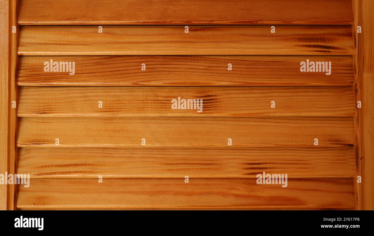 fragment of wooden paneling made of horizontal and vertical planks in the structure of a building or interior, varnished boards of natural wood Stock Photo