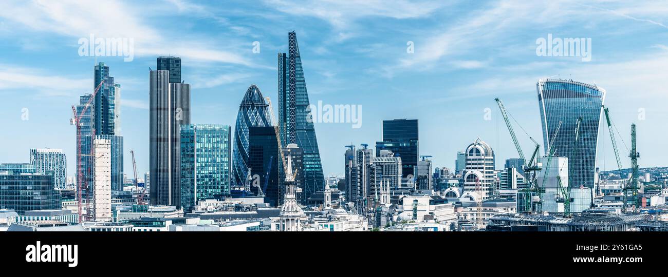Panoramic view of London's iconic skyline featuring modern skyscrapers under a bright blue sky. Stock Photo