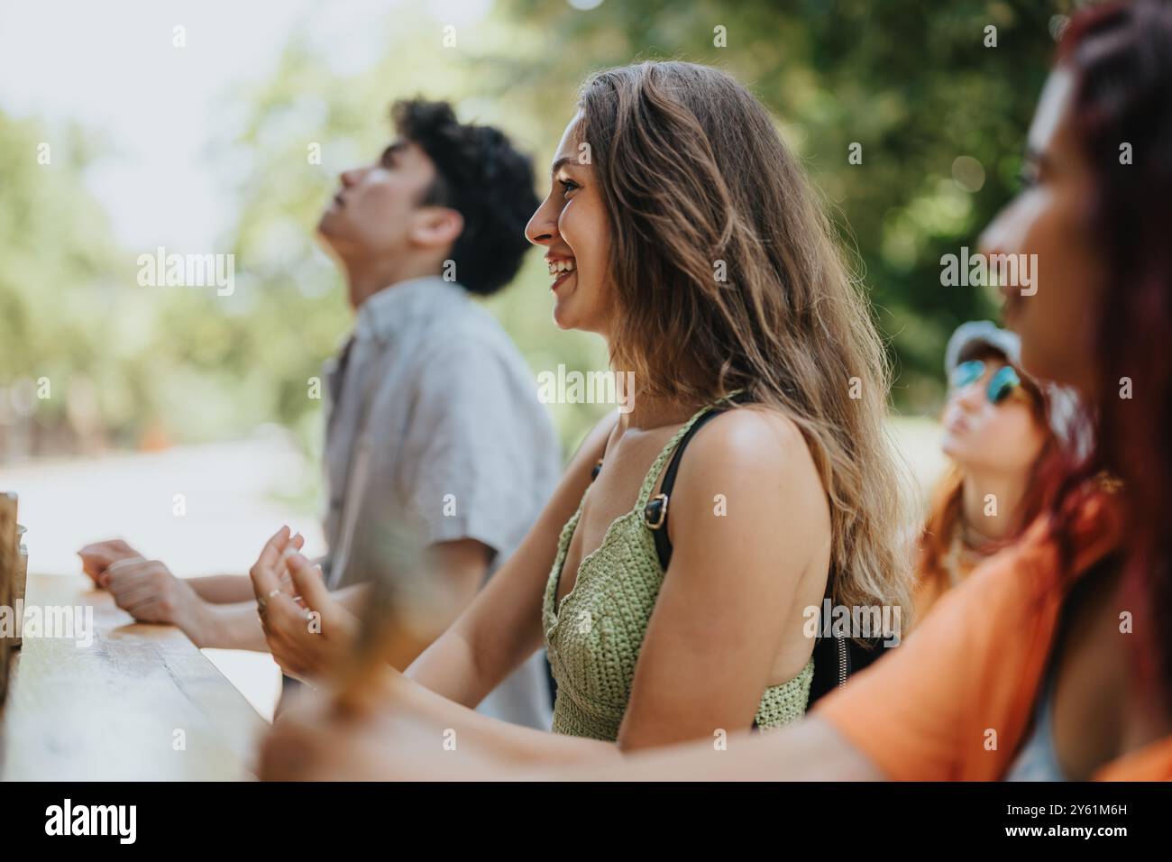 Happy friends enjoying a day out in the park, laughing and relaxing ...