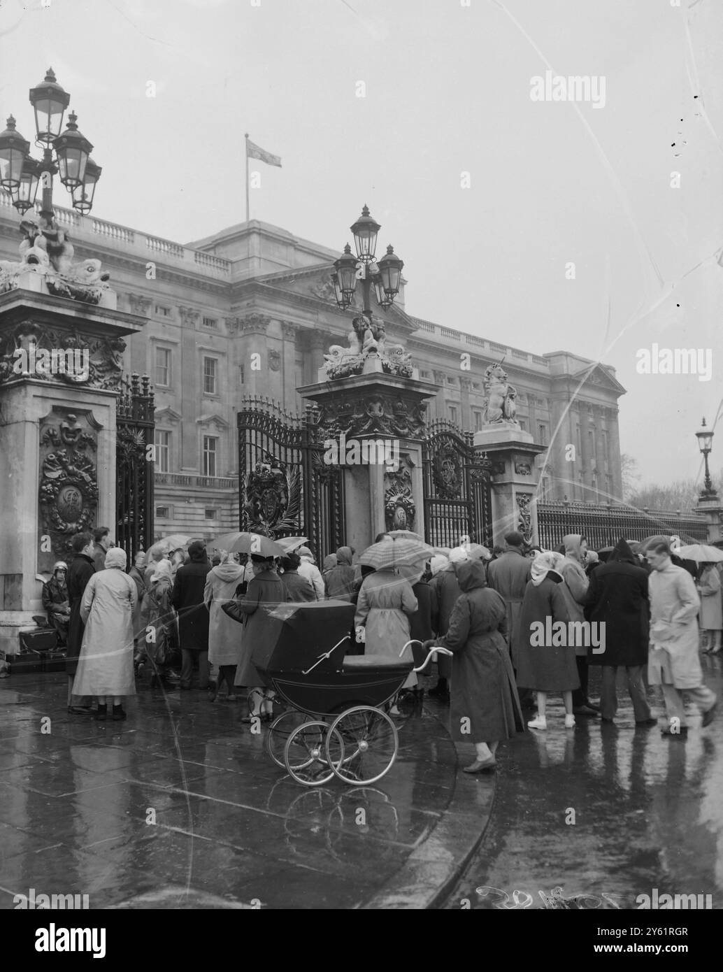 CROWDS IN RAIN OUTSIDE BUCKINGHAM PALACE WAIT FOR NEWS OF QUEEN AND NEWLY BORN PRINCE ANDREW 20 FEBRUARY 1960 Stock Photo