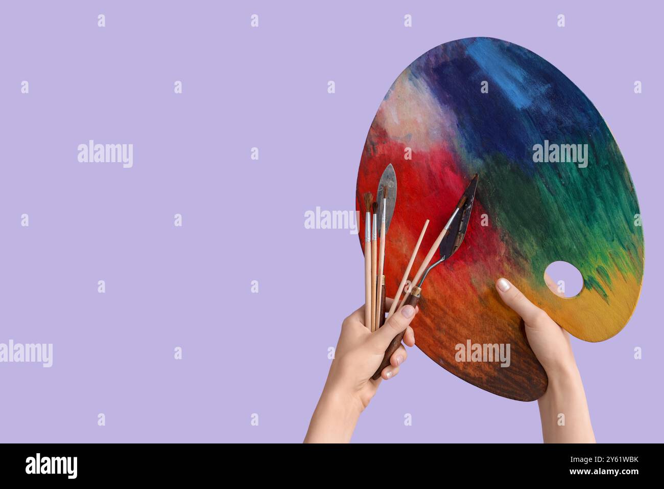 Female hands with artist's supplies on lilac background Stock Photo - Alamy
