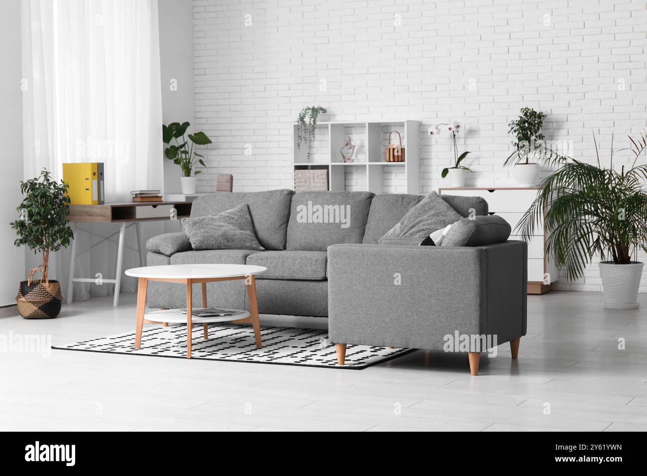 Interior of stylish living room with grey sofa, armchair and table ...