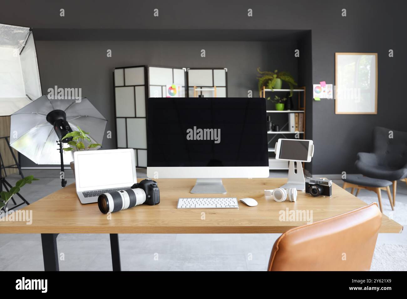 Photographer workplace with computer, laptop and photo camera in modern ...