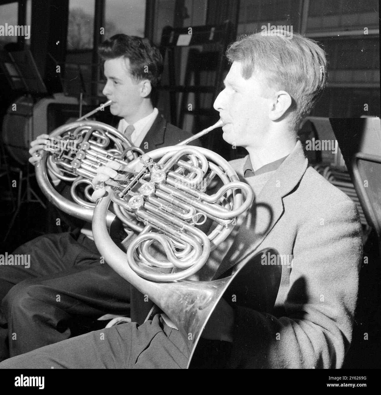 LONDON A CHRISTMAS COURSE BY THE LONDON SCHOOLS SYMPHONY ORCHESTRA IN PREPARATION FOR THEIR 18 JANUARY CONCERT AT THE ROYAL FESTIVAL HALL BEGAN AT QUINTIN SCHOOL IN ST JOHNS WOOD IN LONDON.  PHOTO SHOWS : SOLEMNLY BLOWING ON HIS FRENCH HORN IS 19 YEAR OLD RONALD HARRIS OF LEWISHAM WHO SOLOS IN MOZARTS HORN CONCERTO IN D DURING THE REHEARSALS.  28 DECEMBER 1959 Stock Photo