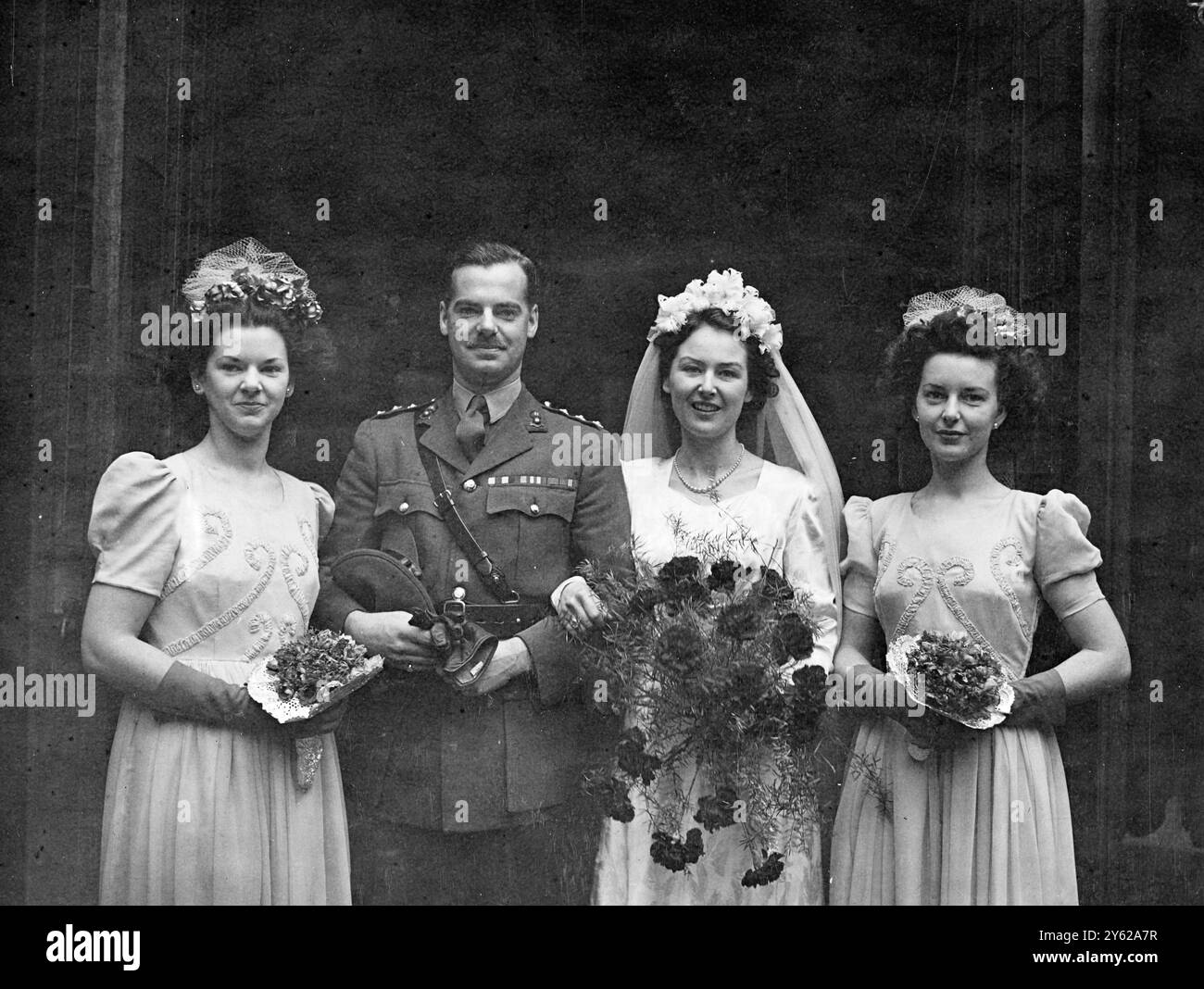 At St Mary's Abbots Church, Kensington Richard Howard Strafford, Son of Capt and Mrs H.W.Stafford, of Shrewsbury, was married to the Vivien Mary, only daughter of Mr and Mrs Cyril Scott of London. Picture Shows: the Bride and Bridegroom after their wedding today with the bridesmaids.  12 December 1947 Stock Photo