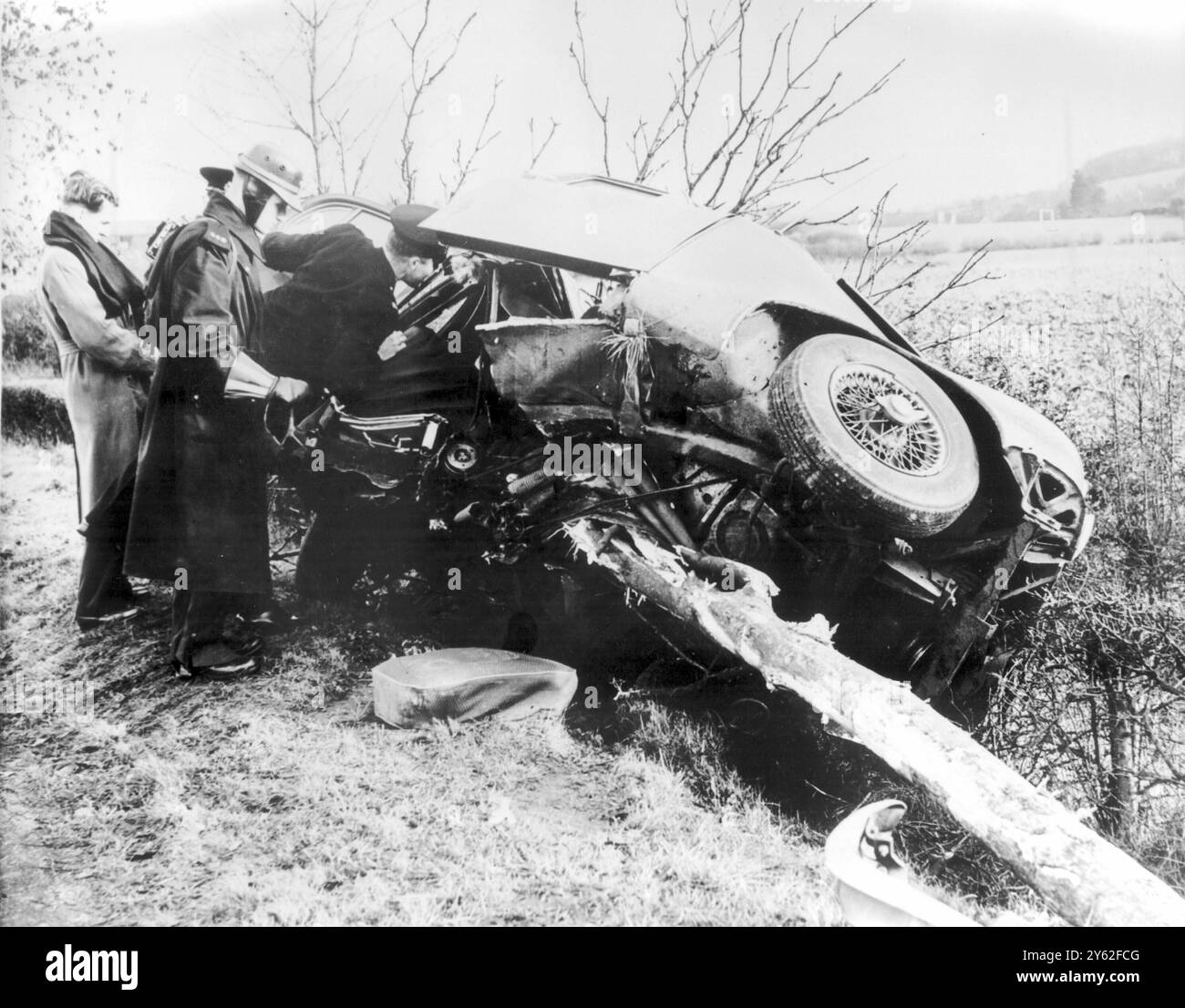 Police were inspecting the wreakage of Mike Hawthorn's Jaguar, after he