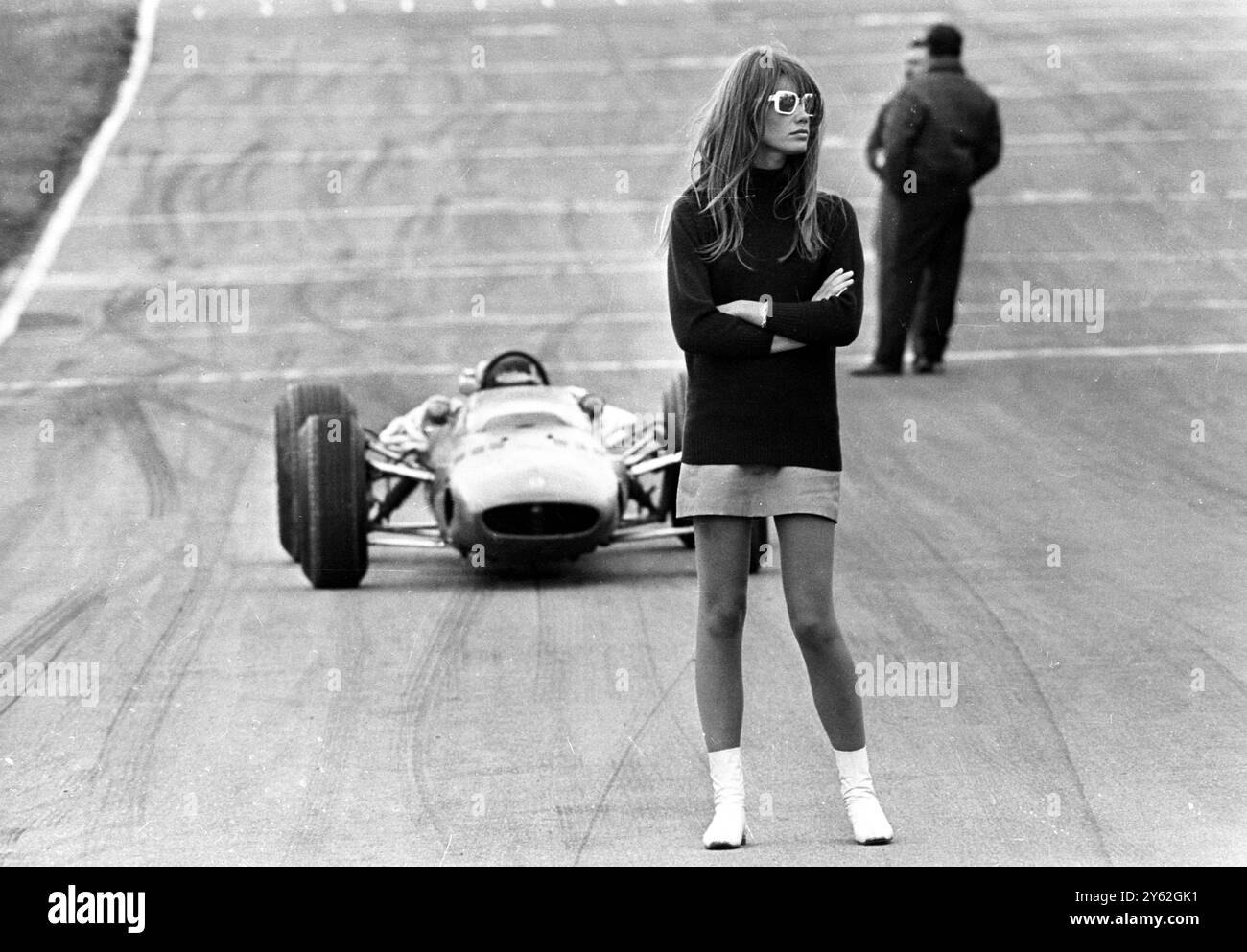 Look out , beautiful . Brands Hatch , England ;  Nonchalent hazard for racing drivers is 22 year old French actress and teenagers' idol , Francoise Hardy , claimed as the originator of the mini - skirt .  Francoise , however , hasn ' t just wandered on to the  track .  She ' s there for sequences in a new movie , entitled , appropriately , ' Grand Prix ' .   12 July 1966 Stock Photo