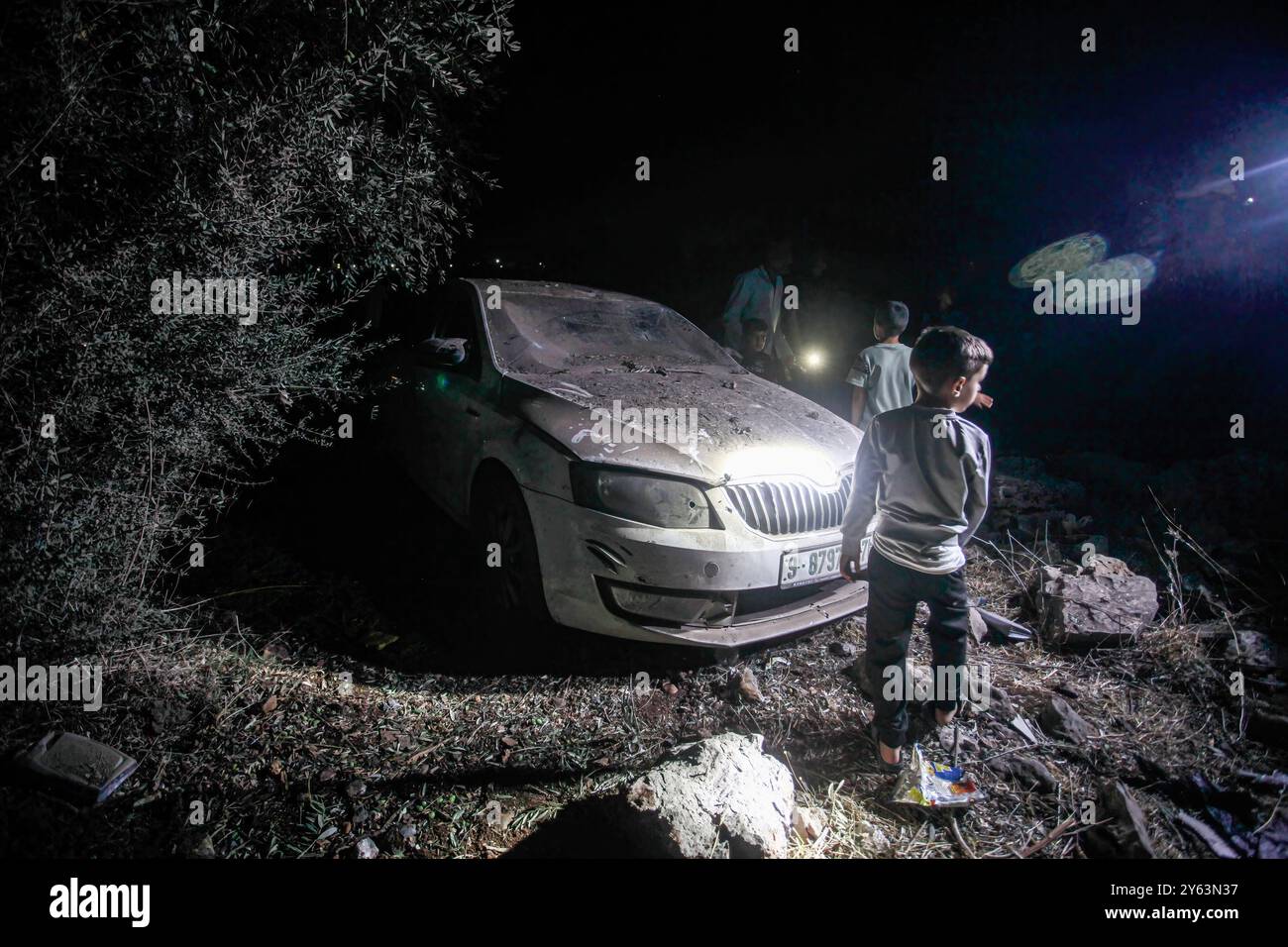 Salfit, West Bank, Palestine. 23rd Sep, 2024. Palestinians inspect a car destroyed by a Hezbollah rocket fired from Lebanon, in the village of Deir Istiya, near the city of Salfit, in the northern occupied West Bank. (Credit Image: © Nasser Ishtayeh/SOPA Images via ZUMA Press Wire) EDITORIAL USAGE ONLY! Not for Commercial USAGE! Stock Photo