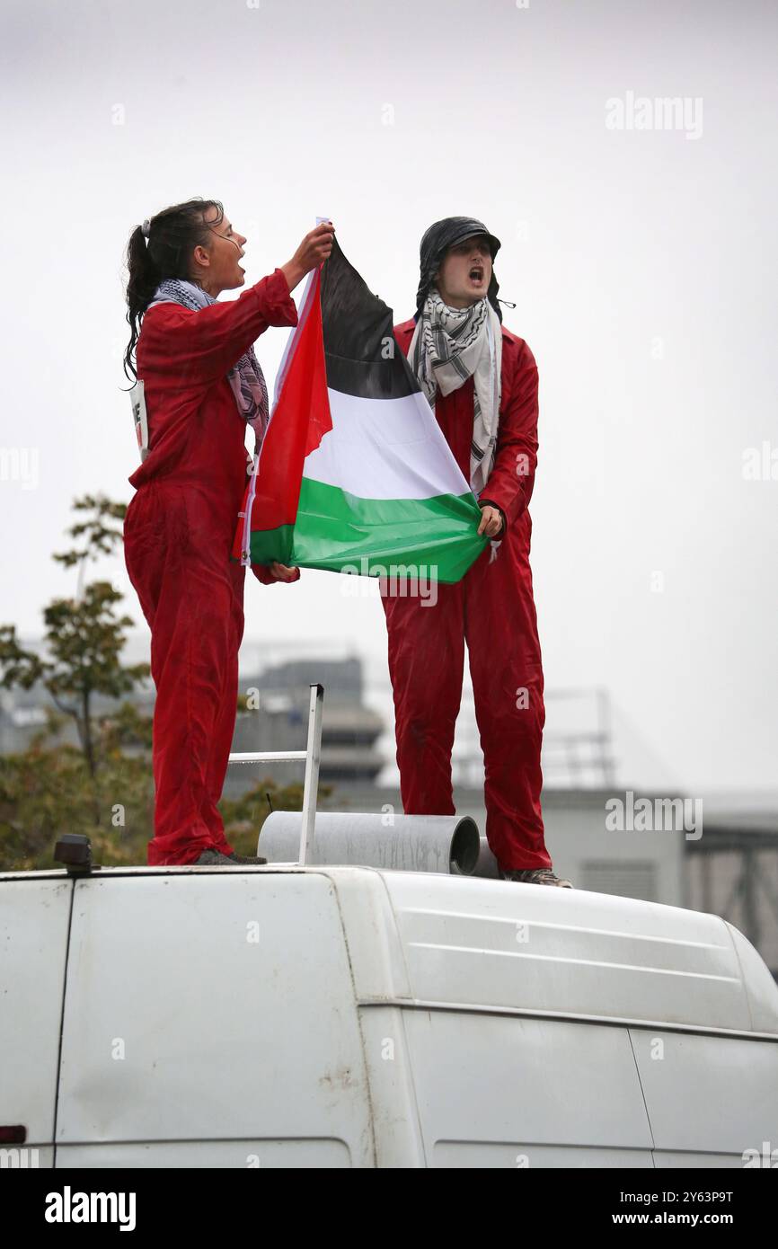 Protesters hold up a Palestine flag and chant from on top of their van during the demonstration. Palestine Actionists blockade the entrance roadway at the research centre of Israel weapons producer Elbit Systems at Filton, Bristol, Elbit produces drones that are being used currently against Palestinians in Gaza and elsewhere. The protesters also wanted to highlight the case of the Filton10 who were all arrested when pro-Palestine activists smashed their way into the Elbit Systems factory back in August 2024. They were arrested under anti-terrorist legislation which allows the police to questio Stock Photo