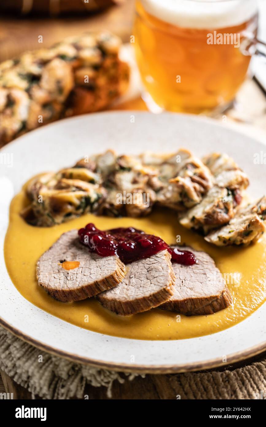 Beef fillets from sirloin steak with traditional Czech sauce, Karlovy Vary dumpling with cranberries and good Czech beer. Stock Photo