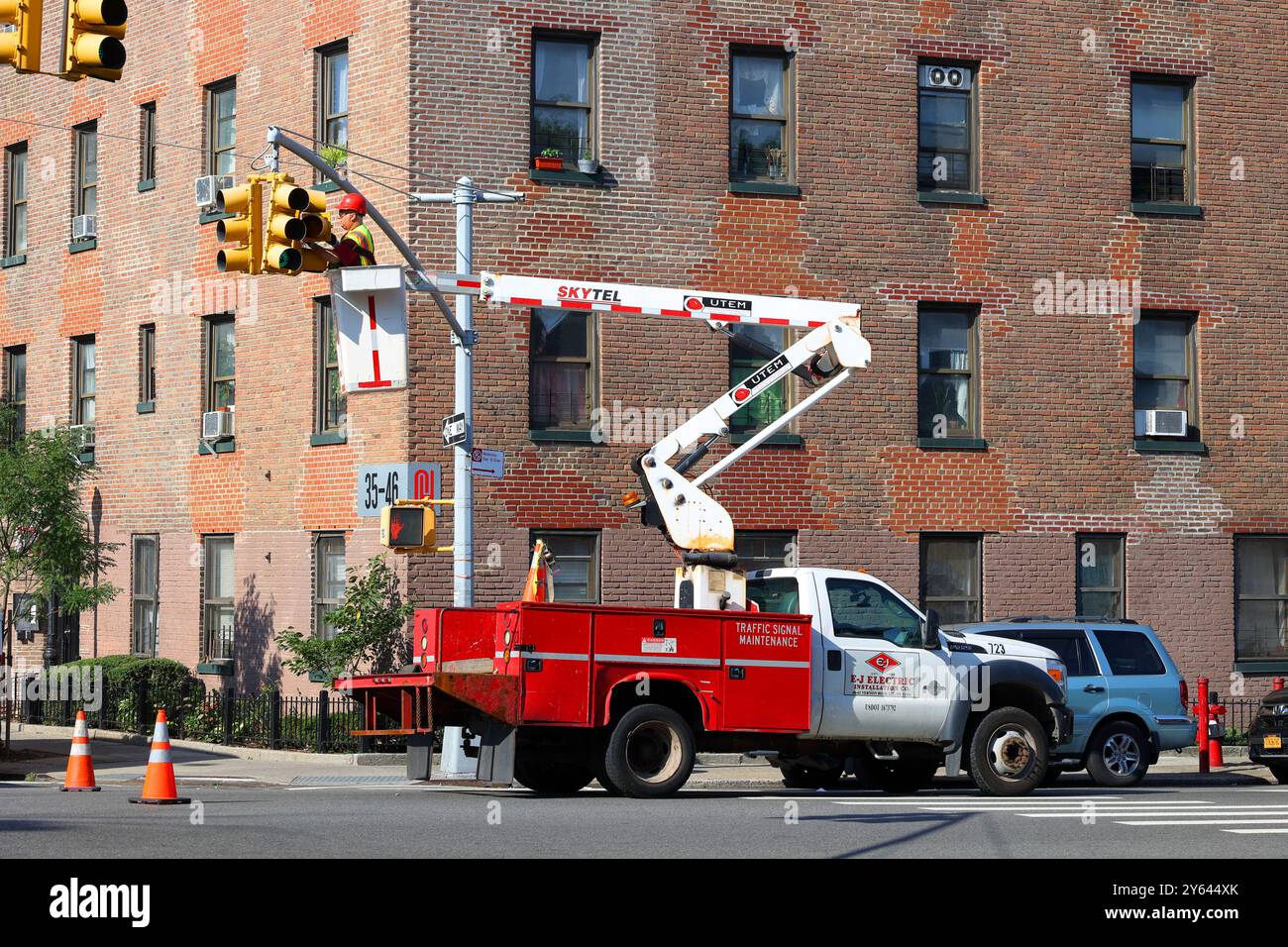 An electrician in a UTEM Skytel bucket truck or aerial lift truck, wiring or repairing a traffic light or traffic signal. Stock Photo