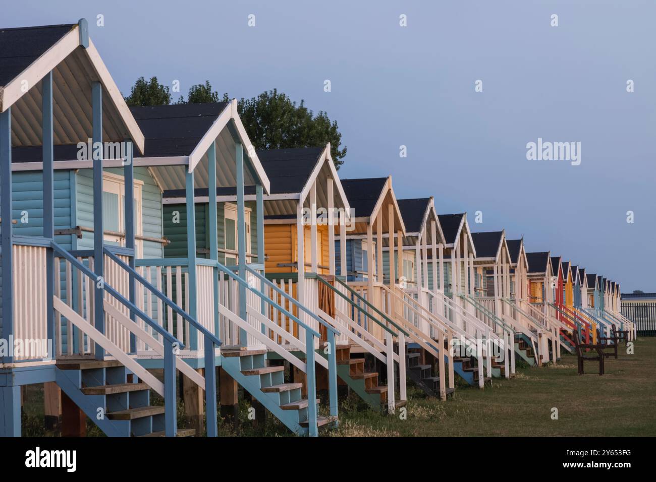 England, Kent, Isle of Sheppey, Leysdown on Sea, Row of Colourful Beach Huts Stock Photo