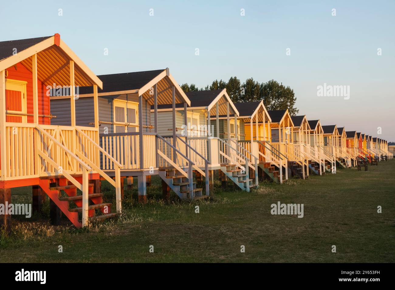 England, Kent, Isle of Sheppey, Leysdown on Sea, Row of Colourful Beach Huts Stock Photo